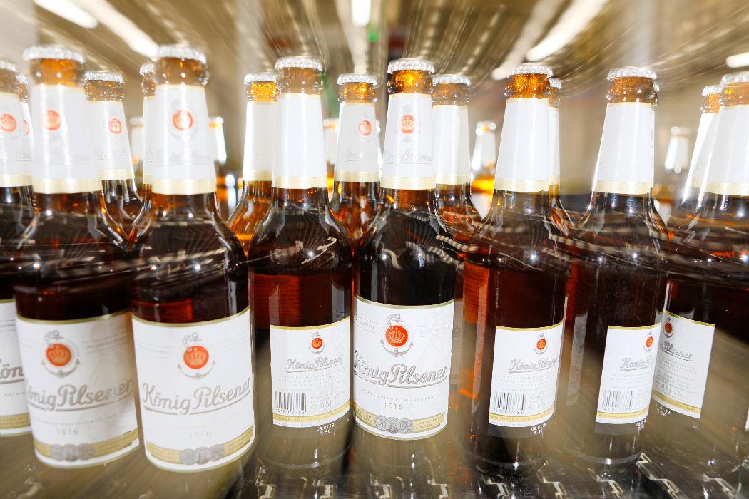 The ready-filled König Pilsener bottles are lined up one after the other before they are finally packaged for dispatch