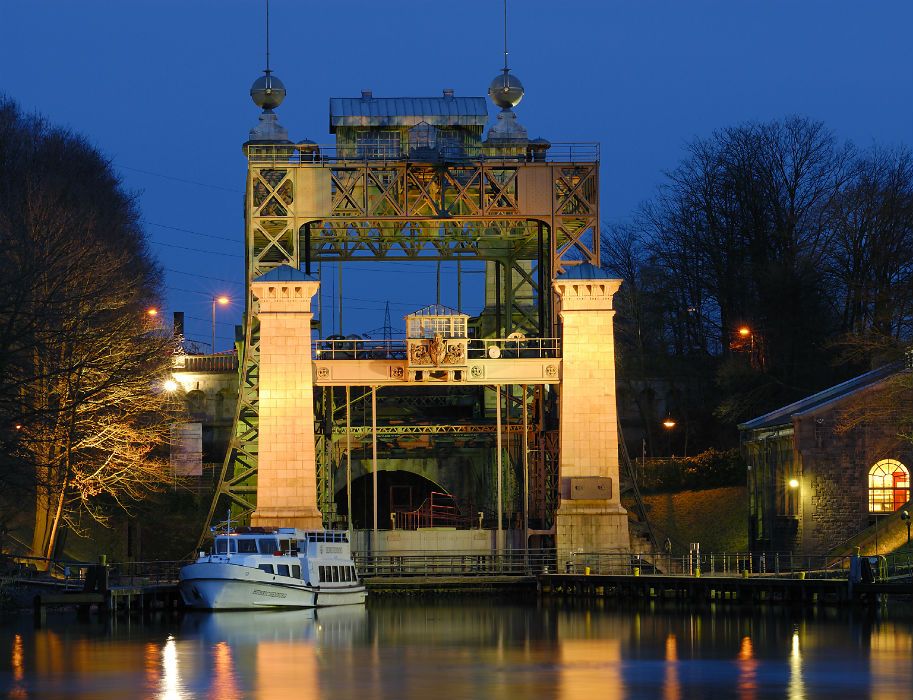 In the evening, the historic industrial building of the LWL Henrichenburg ship lift is brightly illuminated