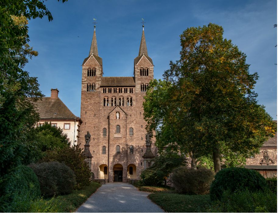 Tourismus NRW e.V., Die Fassade des Westwerkes hinter Bäumen in Höxter