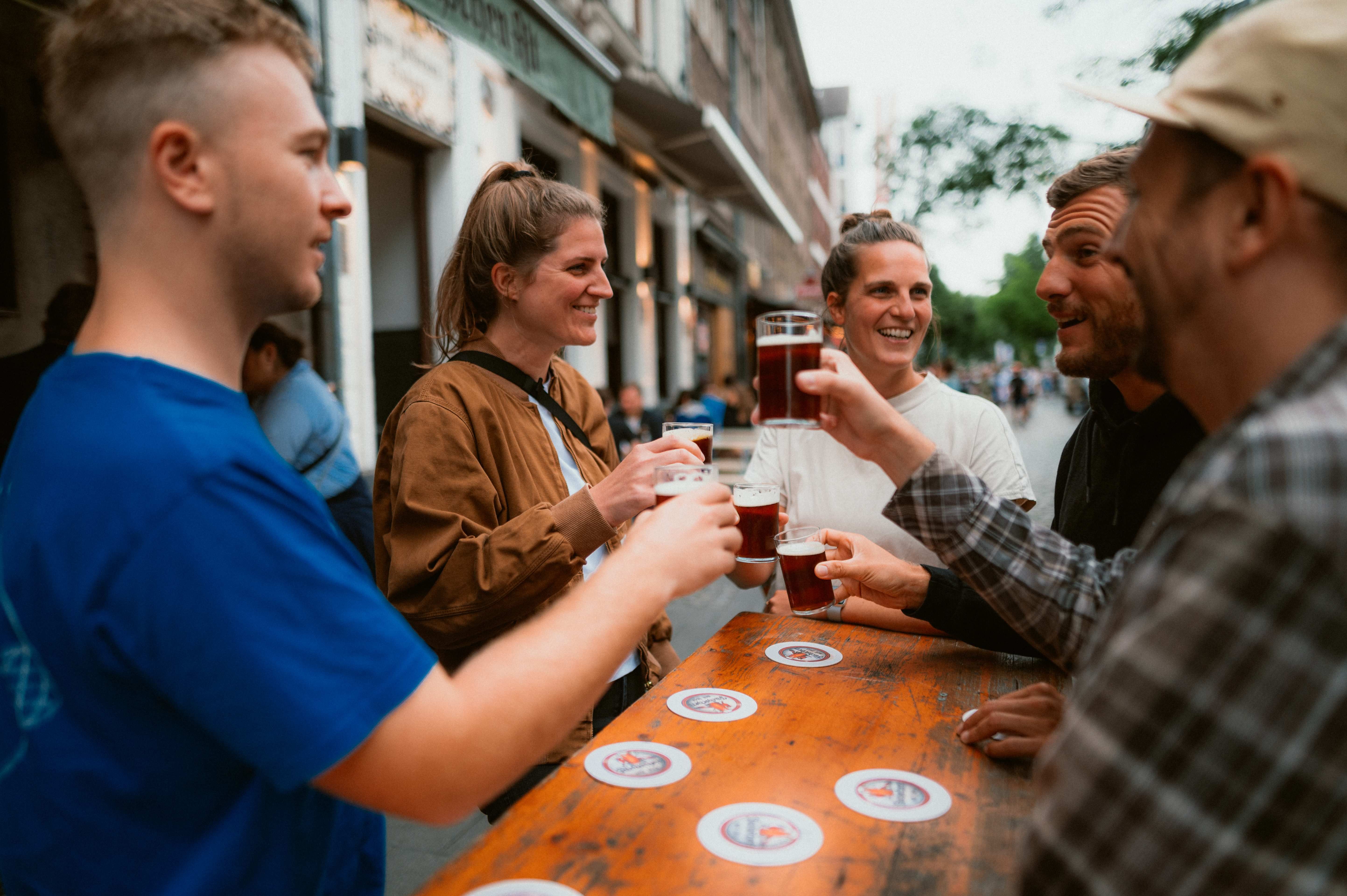 Freunde stehen am Tisch vor Brauhaus