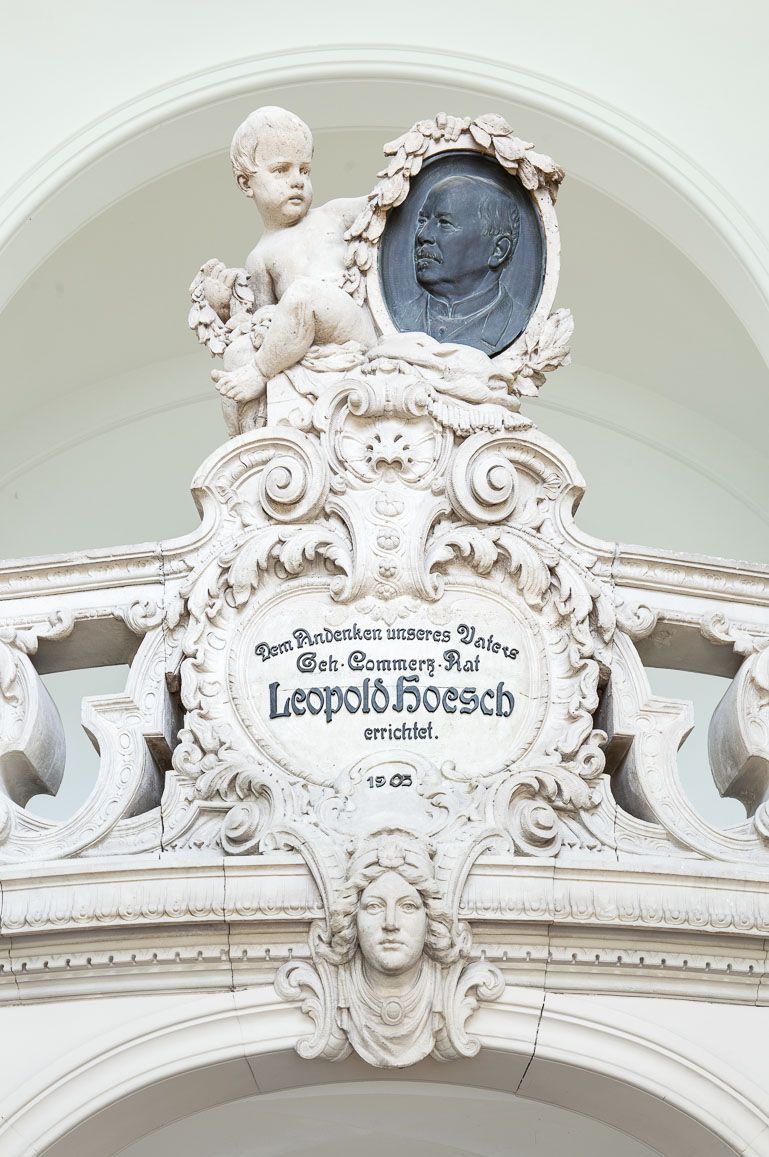 Leopold-Hoesch-Museum, Düren 2024, Foto: Peter Hinschläger, Schriftkartusche und Putto mit Portraitmedaillon Leopold-Hoesch, Eingangshalle des Leopold-Hoesch-Museums, Düren