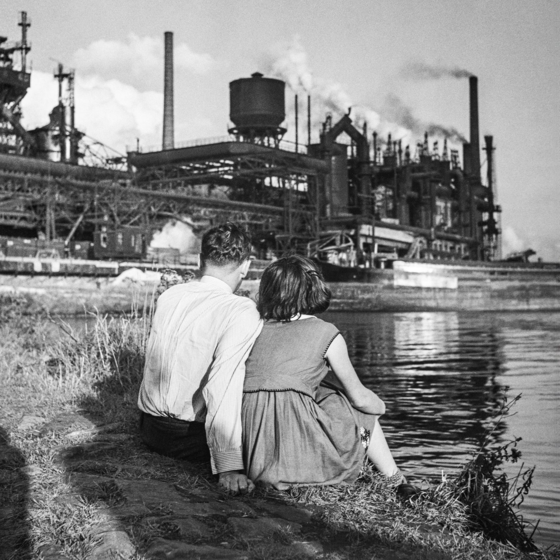 Couple in front of industrial plant