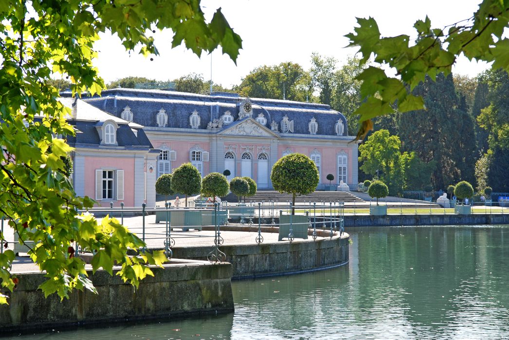 The pink hue of Benrath Palace catches the eye of visitors from the path by the palace pond